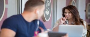 Young Man And Woman Looking At Each Other In A Cafe